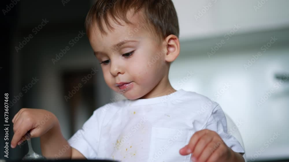 Lovely Caucasian toddler having meals. Kid fills the spoon with soup and gives it to camera. Blurred backdrop. Lovely Caucasian toddler having meals. Kid fills the spoon with soup and gives it to camera. Blurred backdrop.