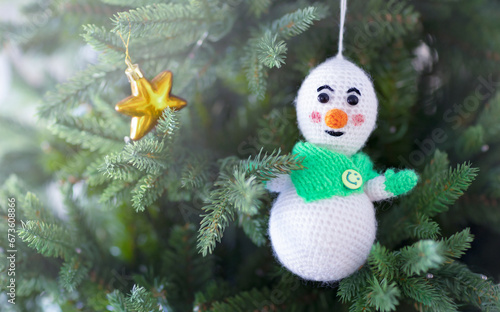 christmas background with a Christmas tree and a knitted snowman photo