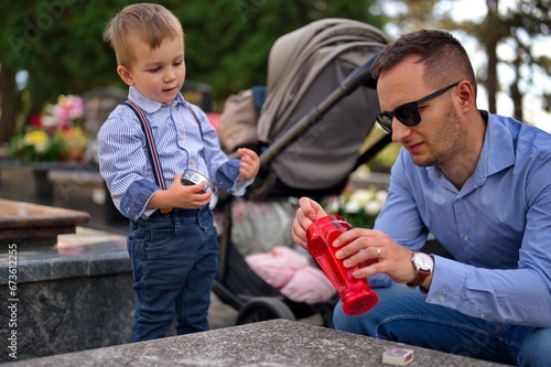 Father and son lighting a candle at the grave © Vedrana