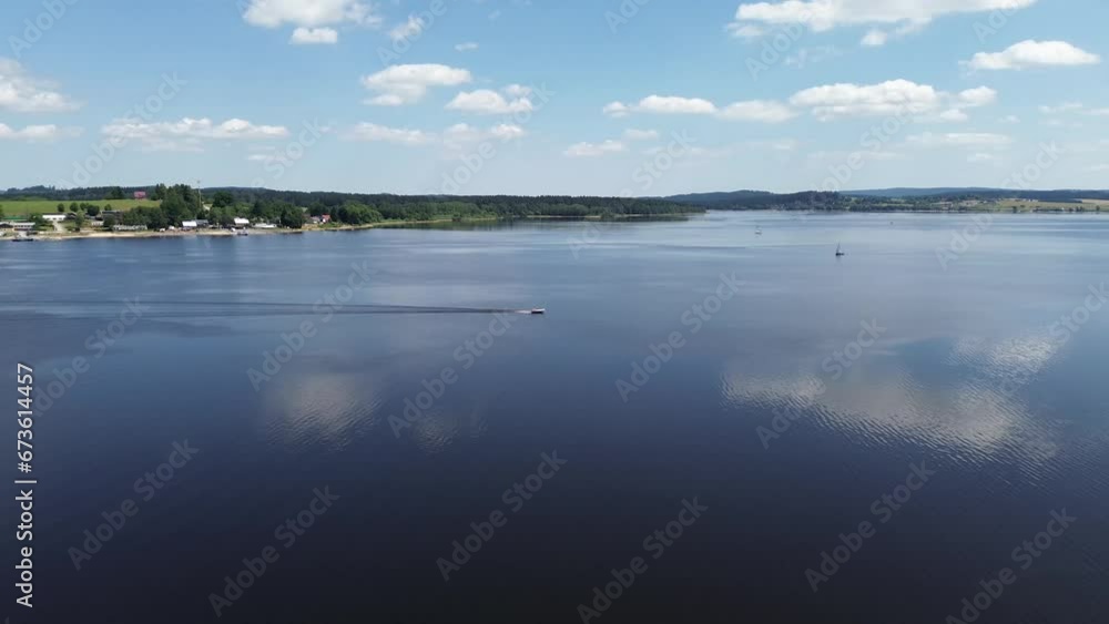 cinematic view in motion of a ship sailing across a large blue lake cinematic view in motion of a ship sailing across a large blue lake