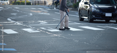 街の交差点の横断歩道を渡るシニア男性の姿 photo