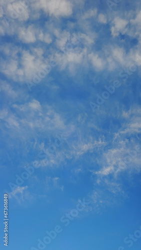 High-quality vertical panorama Bright blue sky with light ragged feathery clouds of an interesting shape