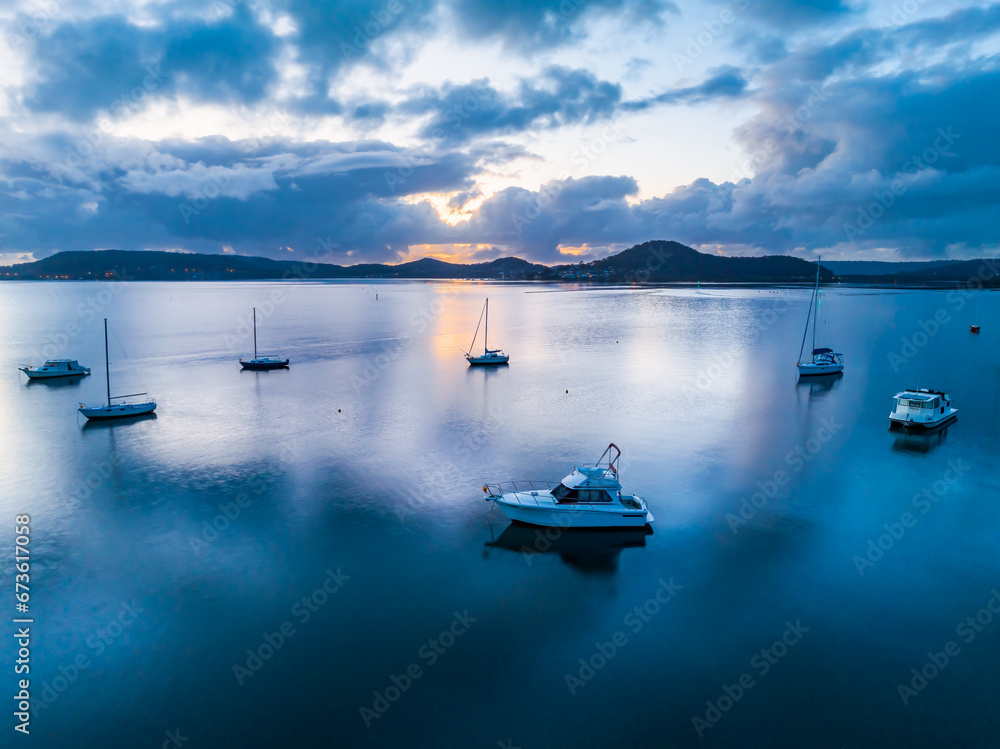 Sunrise blues over the bay with boats and clouds