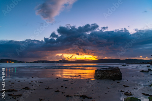 Moody sunrise at the seaside with rain clouds