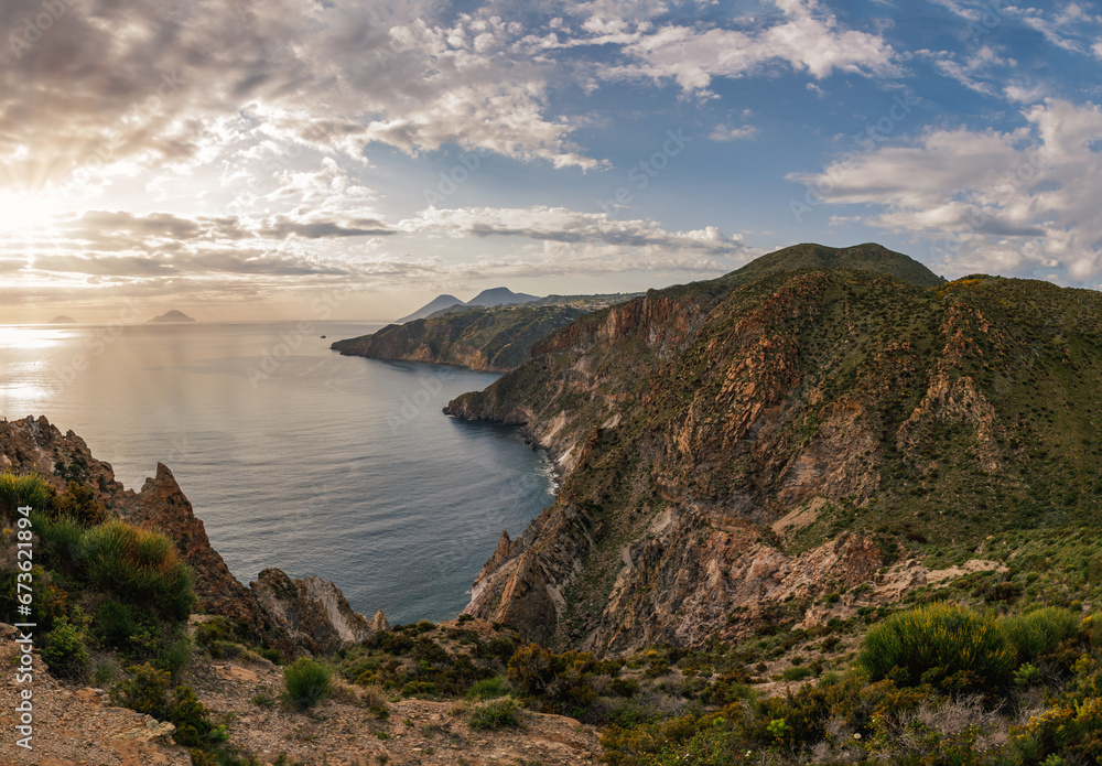 Stunning view of the sunset over the bay and coast with cliffs and mountains on the island of Lipari - one from the group of Aeolian Islands in Tyrrhenian Sea, Sicily, Italy