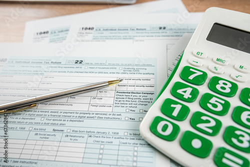 pen caluclator 1040 tax form on office desk, accounting concept photo