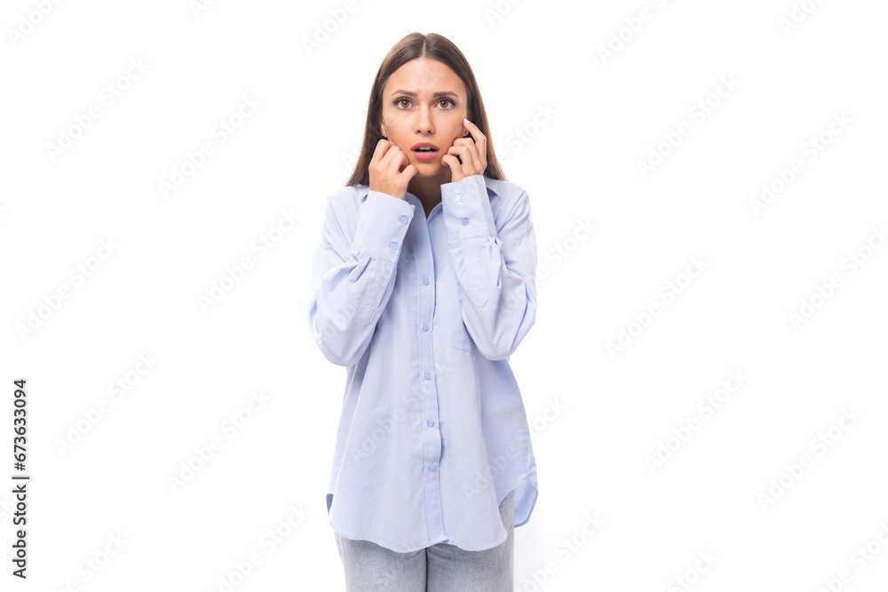 young surprised european business lady with long black hair dressed in a blue blouse on a white background with copy space young surprised european business lady with long black hair dressed in a blue blouse on a white background with copy space