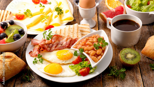 healthy full breakfast with fried egg, toast and bacon with coffee cup and frresh fruit