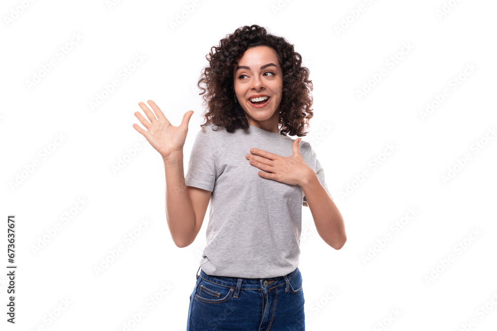 young surprised pretty brunette curly caucasian lady in casual jeans on white background with copy space young surprised pretty brunette curly caucasian lady in casual jeans on white background with copy space