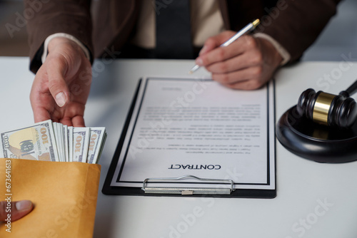 Government tax officials, legal advisers taking bribes of citizens wrapped in brown envelopes. Opening the annual tax evasion, the concept of bribing tax evader officials. photo