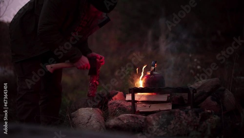 A Man Employing Cut Wood for Cooking in Hildremsvatnet, Norway - Close Up photo