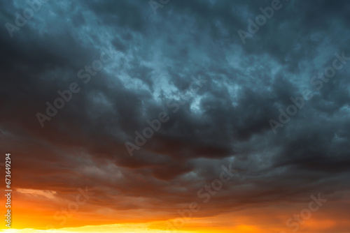 Tablou pe pânză Dramatic sky at sunset, dangerous heavy gray orange color clouds in sky, abstrac