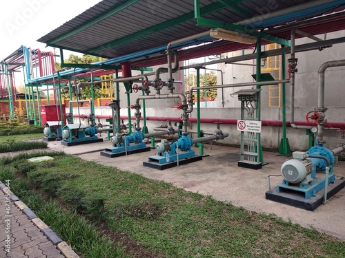 pump and electric motor installation in a factory with caution of Not using Cellphone in Indonesian Language © Nurchabib