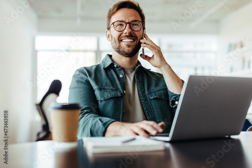 Entrepreneur making a phone call while working in an office photo