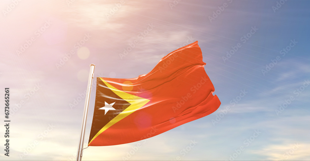 East Timor national flag waving in beautiful sky. The symbol of the state on wavy silk fabric.