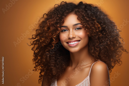 African beautiful woman portrait. Brunette curly haired young model with dark skin and perfect smile.