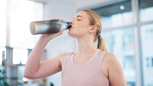 Woman, home and drink of water for sports break, energy and workout performance. Thirsty athlete, bottle and nutrition of hydration, diet or healthy liquid for training, exercise or fitness in lounge