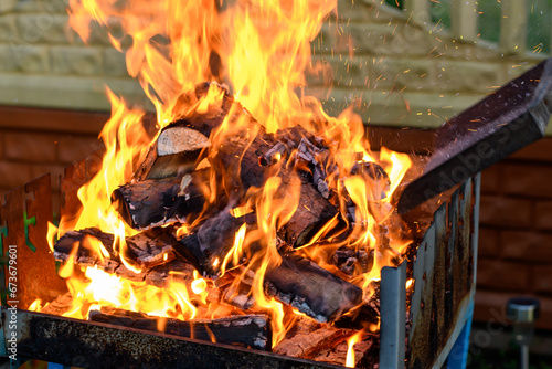 Rozpalanie grilla ogrodowego za pomocą suchego drewna opałowego, ognisko w palenisku 