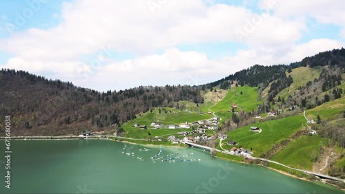 a panoramic aerial view of an idyllic alpine lake showcasing the picturesque  village of Innerthal on the pristine shores of wägitalersee Lake in the Swiss Alps 
 photo
