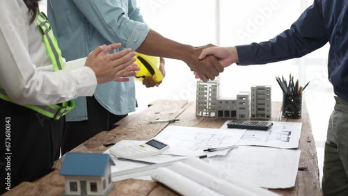 Holding hands at a construction site An employee or worker shakes hands with an employer to greet, agree, work as a team, cooperate in a project or real estate business.