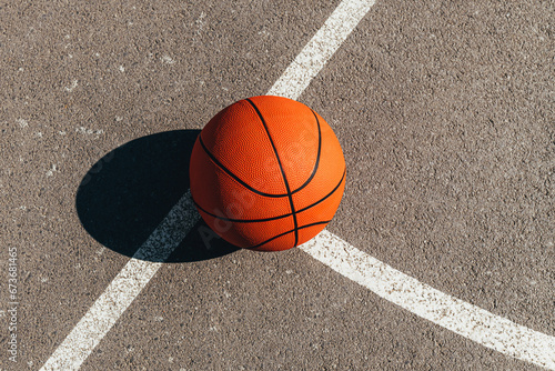 Basketball ball on outdoor court with asphalt surface