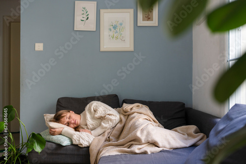 Stressed woman sleeping on sofa at home photo