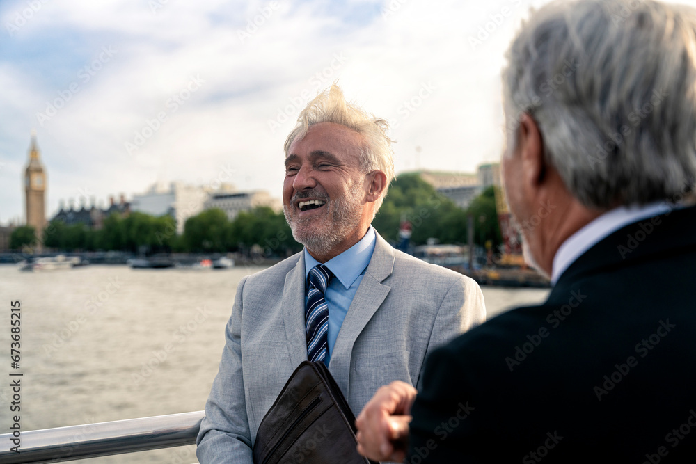 Happy businessman with colleague in front of Thames river Happy businessman with colleague in front of Thames river