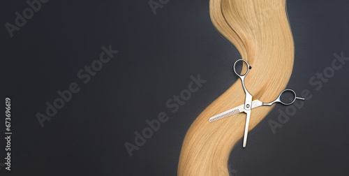 Flat lay composition with light hair, comb, scissors and space for text on black background. Hairdresser service. Hair extensions, materials and cosmetics, hair care, wig. Hairstyle, haircut salon.