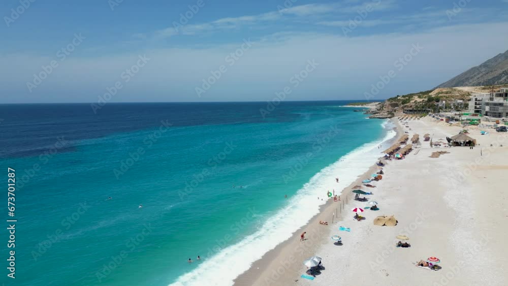Aerial shot of beautiful sandy mediterranean beach with tourists swimming on the shore on a summer day Aerial shot of beautiful sandy mediterranean beach with tourists swimming on the shore on a summer day