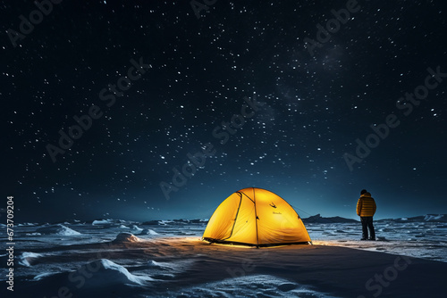 Illuminated yellow tent at night in snowy mountains with person standing next to it and starry sky, long night exposure of tent in mountains.generative ai
