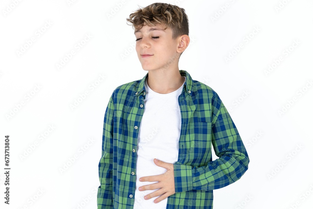 Caucasian teen boy touches tummy, smiles gently, eating and satisfaction concept. Caucasian teen boy touches tummy, smiles gently, eating and satisfaction concept.