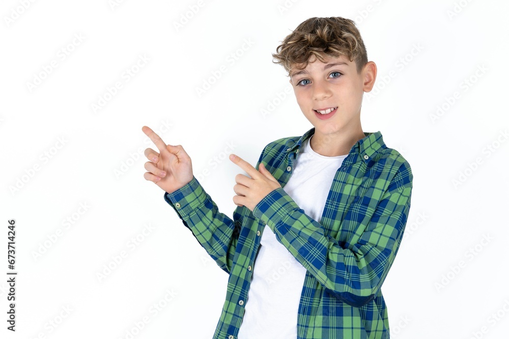 Caucasian teen boy indicating finger empty space showing best low prices, looking at the camera Caucasian teen boy indicating finger empty space showing best low prices, looking at the camera