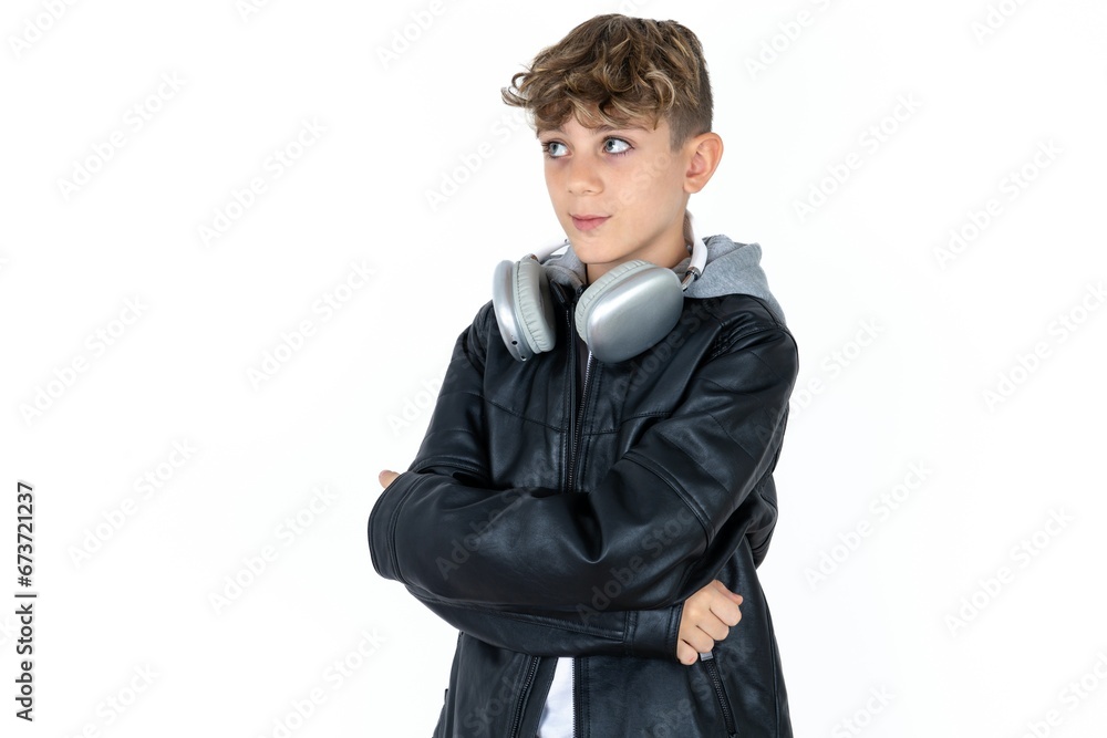 Pleased caucasian kid boy wearing blue vest keeps hands crossed over chest looks happily aside Pleased caucasian kid boy wearing blue vest keeps hands crossed over chest looks happily aside