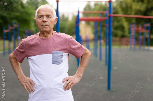 Portrait of positive elderly man in sportswear on playground © caftor