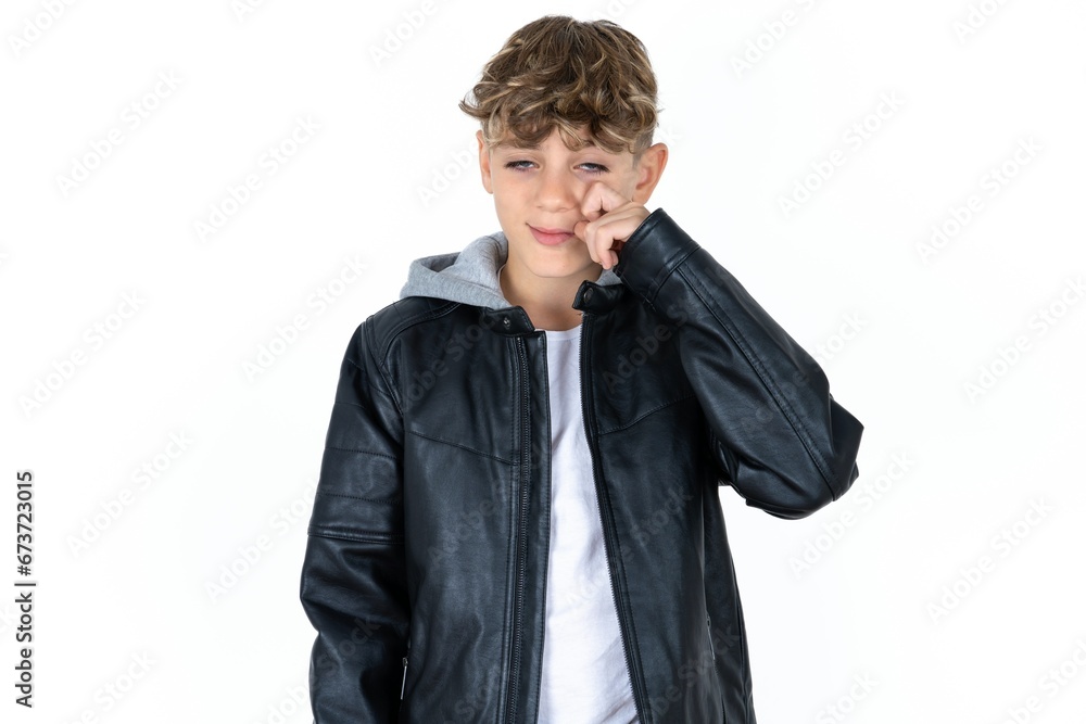 Disappointed dejected caucasian kid boy wearing black jacket wipes tears stands stressed with gloomy expression. Negative emotion Disappointed dejected caucasian kid boy wearing black jacket wipes tears stands stressed with gloomy expression. Negative emotion