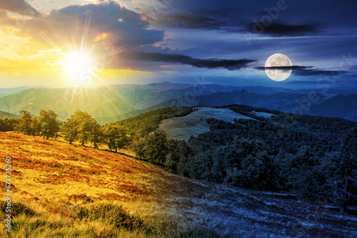 mountainous autumn landscape with sun and moon at twilight. meadow and beech forest on hill. day and night time change concept. mysterious nature scenery in morning light © Pellinni