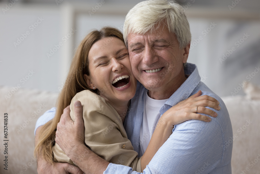 Happy grey haired senior daddy embracing beautiful adult daughter child, looking at camera, smiling, laughing, enjoying leisure, close relationship, affection. Family head shot portrait Happy grey haired senior daddy embracing beautiful adult daughter child, looking at camera, smiling, laughing, enjoying leisure, close relationship, affection. Family head shot portrait