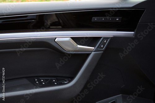 Premium Car door leather trim with windows control. Lux Car Inside Door Handle Interior. Door black leather trim. Front door leather trim of a Prestige car. Modern Car interior. Driver seat memory. © Best Auto Photo