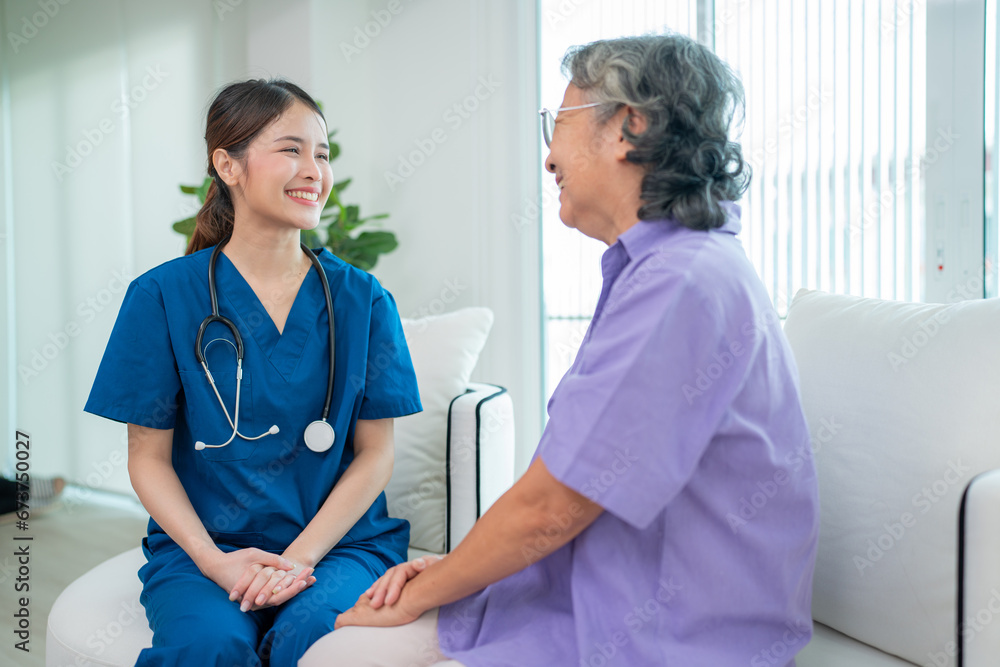 © kelvn - Asian young nurse taking care and talking mature female patient sitting on sofa in hospital. Healthcare concept.