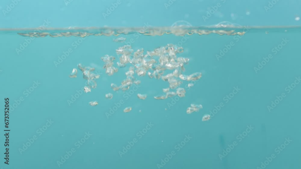 Air bubbles in the water rise upwards on a blue background. close up Air bubbles in the water rise upwards on a blue background. close up
