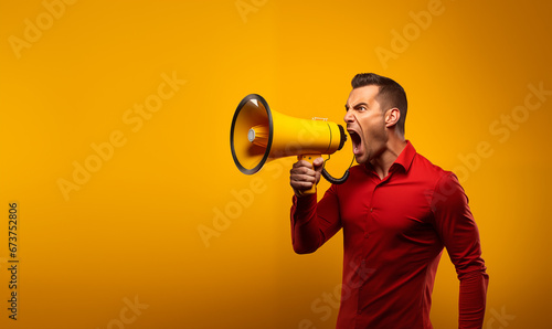 un homme crie dans un mégaphone - fond jaune photo