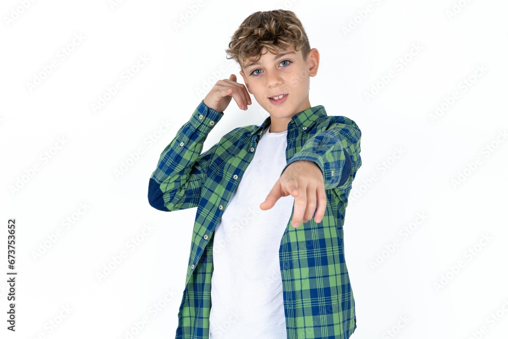 Caucasian teen boy smiling cheerfully and pointing to camera while making a call you later gesture, talking on phone Caucasian teen boy smiling cheerfully and pointing to camera while making a call you later gesture, talking on phone