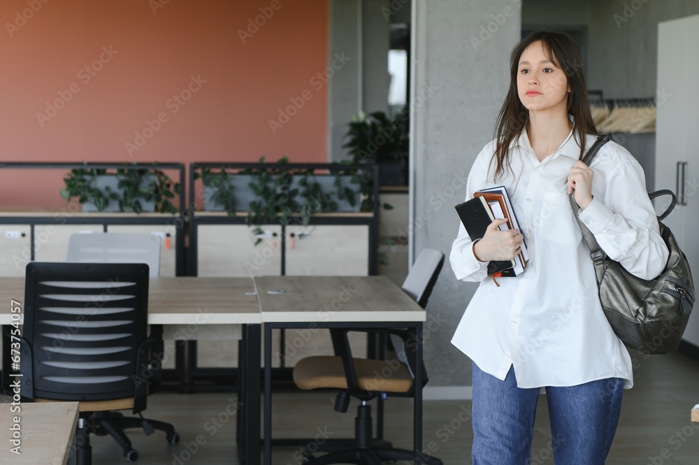 Teen girl studying with textbook writing essay learning in classroom. Teen girl studying with textbook writing essay learning in classroom.