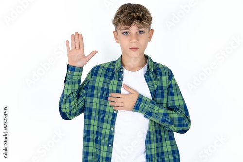 Foto Caucasian teen boy Swearing with hand on chest and open palm, making a loyalty p