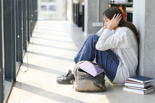 Bild auf Leinwand Asian young girl student sitting alone with sad feeling at school
