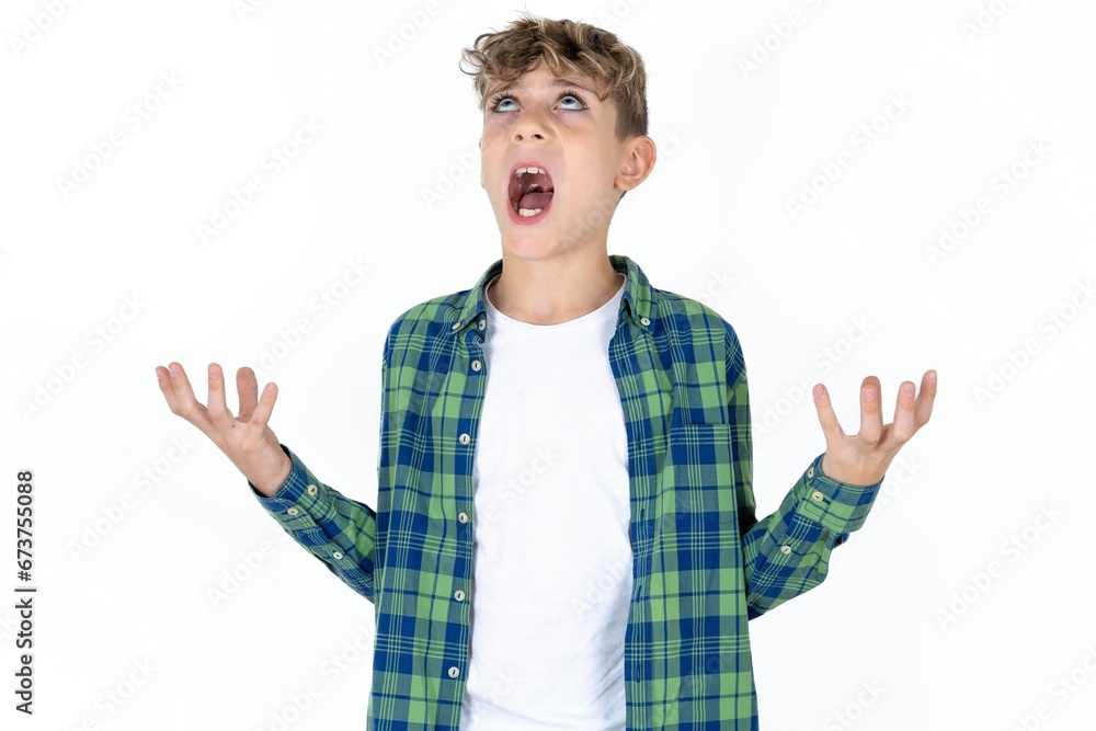 Caucasian teen boy crazy and mad shouting and yelling with aggressive expression and arms raised. Frustration concept. Caucasian teen boy crazy and mad shouting and yelling with aggressive expression and arms raised. Frustration concept.