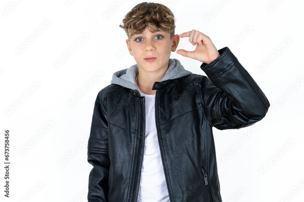 Caucasian teen boy purses lip and gestures with hand, shows something very little. Caucasian teen boy purses lip and gestures with hand, shows something very little.