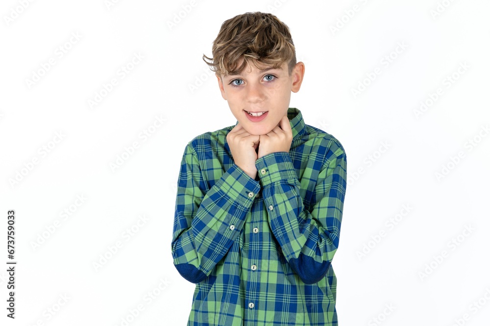 Caucasian teen boy wearing plaid shirt holds hands under chin, glad to hear heartwarming words from stranger Caucasian teen boy wearing plaid shirt holds hands under chin, glad to hear heartwarming words from stranger