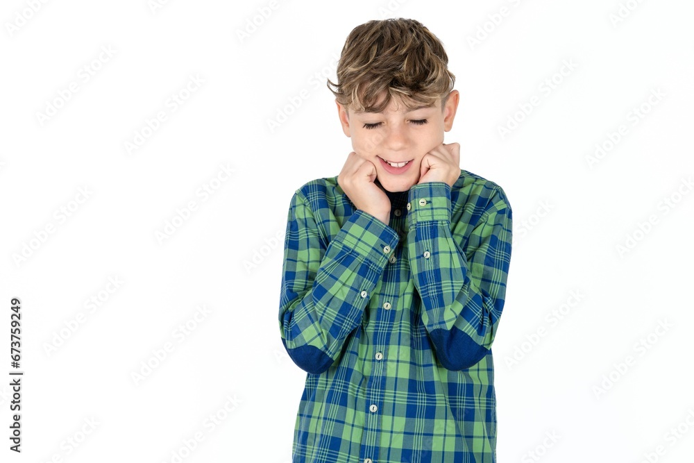 Caucasian teen boy wearing plaid shirt grins joyfully, imagines something pleasant, copy space. Pleasant emotions concept. Caucasian teen boy wearing plaid shirt grins joyfully, imagines something pleasant, copy space. Pleasant emotions concept.