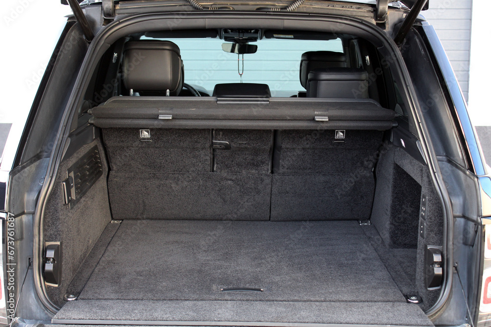 Huge, clean and empty car trunk in interior of lux suv. Rear view of a SUV car with open trunk